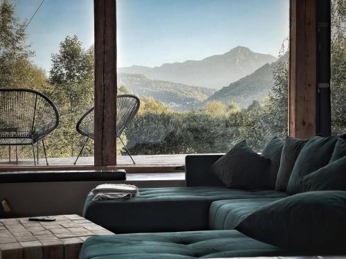 ein Wohnzimmer mit einem Sofa und einem großen Fenster in der Unterkunft GEIST holiday home in Râșnov