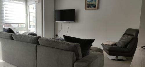 - un salon avec un canapé et une chaise dans l'établissement Appartement Dumortier, à Knokke-Heist