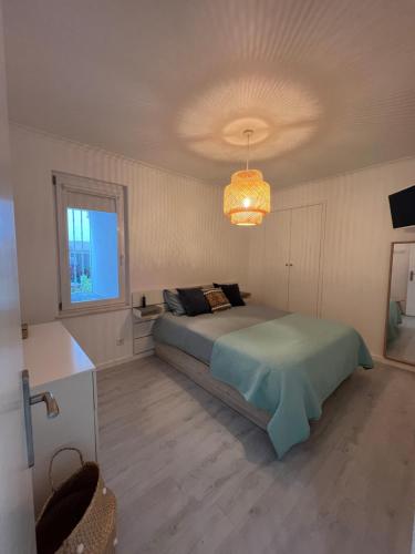 a bedroom with a bed and a chandelier at Bluebay Sesimbra - Laura in Sesimbra