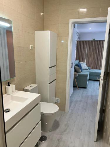 uma casa de banho com um lavatório e um WC num quarto em Bluebay Sesimbra - Laura em Sesimbra