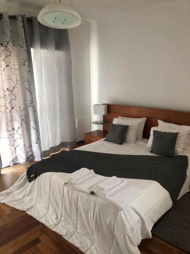 1 dormitorio con 2 camas con sábanas blancas en Faustina's suite en Portimão
