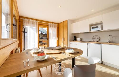 安格勒的住宿－Appartement ESCAL，厨房配有木桌和白色橱柜。