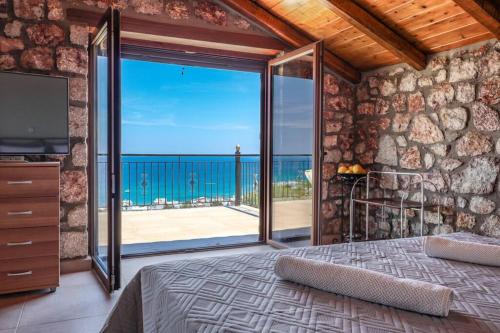 a bedroom with a bed and a view of the ocean at Petronas Land House 2 in Archangelos