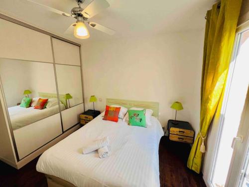 1 dormitorio con 2 camas y espejo en Maison des Oliviers : Maison 5 Prs, 400m plages, en Antibes