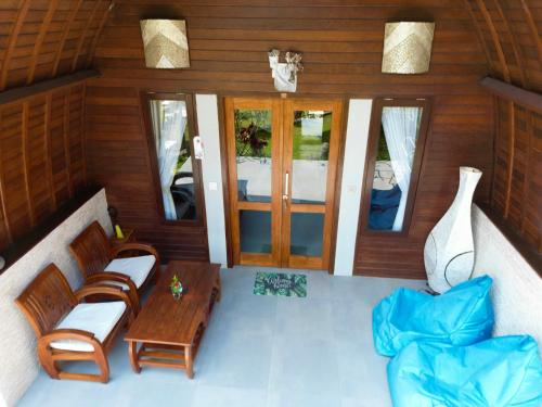 a room with chairs and a table and glass doors at Jungle Paradise in Nusa Penida