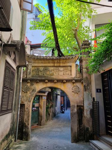 an archway in an alley between two buildings at May's Cottage in Hanoi