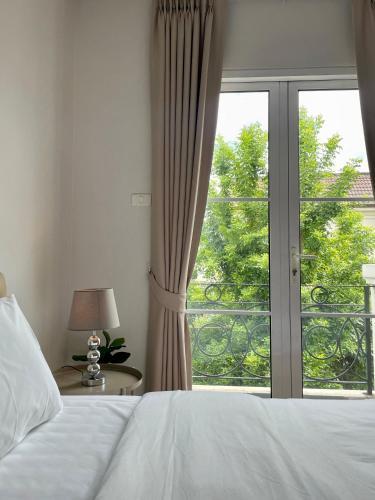 - une chambre avec un lit et une grande fenêtre dans l'établissement Entire 3BR Townhome in Sukhumvit, shared Pool, near BTS&MRT Asok, à Bangkok