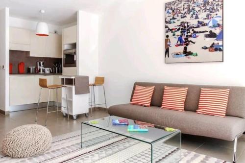 un salon avec un canapé et une table dans l'établissement Le White Pearl : Apt 4 Prs, Parking, Clim, à Antibes
