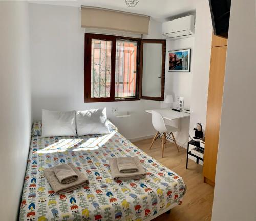 a bedroom with a bed with two towels on it at Habitación González in Málaga
