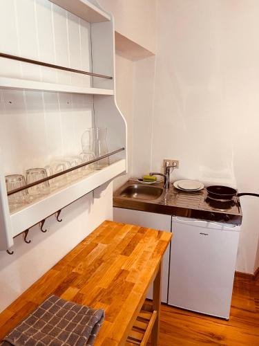 cocina con fregadero y mesa de madera en Graz City Centre Apartment, en Graz