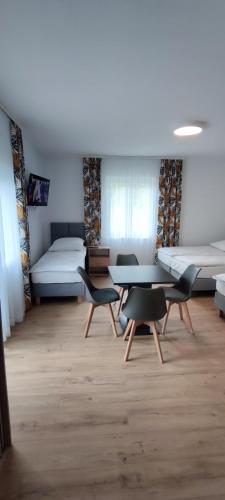a room with a table and chairs and a bed at Zakręt Solina BALIA RELAKS 537-791-246 in Solina