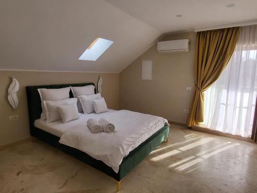 a bedroom with a large bed with two towels on it at Sika Palladium Central Apartment in Arad
