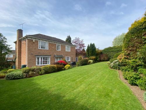 a large brick house with a green lawn at Spacious 4 Bedroom House with Garden and Parking in Ecclesall
