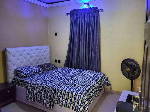 - une chambre avec un lit et un rideau pourpre dans l'établissement TSOLID HOMES, à Ibadan