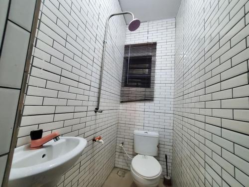 La salle de bains blanche est pourvue de toilettes et d'un lavabo. dans l'établissement TSOLID HOMES, à Ibadan