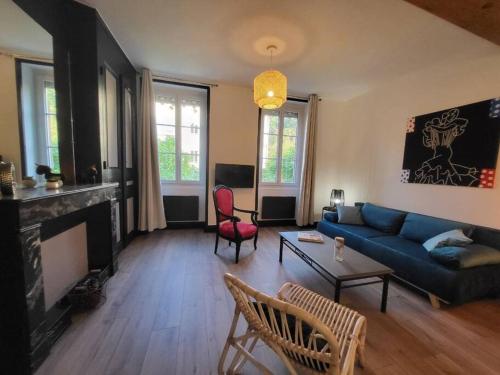 un salon avec un canapé bleu et une cheminée dans l'établissement Ô Bon'Endroit - Appartement Confort - Centre Ville, à Vienne