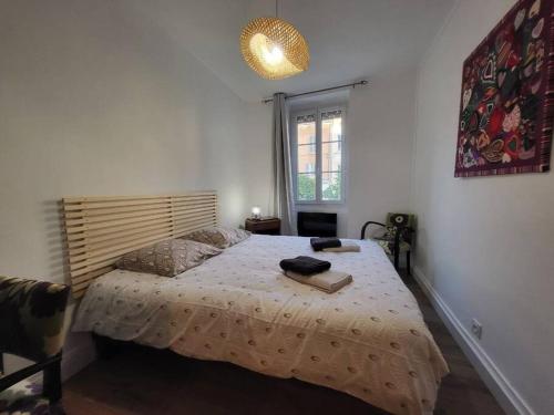una camera da letto con un letto grande e una finestra di Ô Bon'Endroit - Appartement Confort - Centre Ville a Vienne
