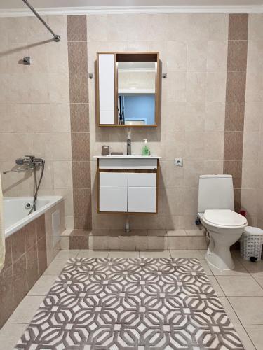 ein Badezimmer mit Waschbecken, Toilette und Spiegel in der Unterkunft 2-х комнатная в Золотом квадрате in Almaty