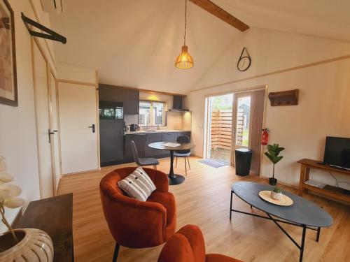 2-persoons luxe vakantiewoning في De Veenhoop: غرفة معيشة مع أريكة وطاولة