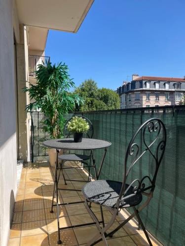 balcone con tavolo e sedie. di Appartement confortable entre Paris et Versailles a Ville-dʼAvray