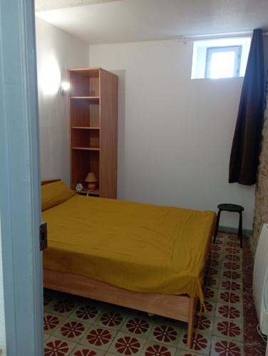 um quarto com uma cama com uma colcha amarela em Maison entière Coeur village em Argelès-sur-Mer