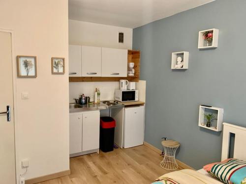 eine kleine Küche mit weißen Schränken und einer Mikrowelle in der Unterkunft Studio Helden in Illkirch-Graffenstaden