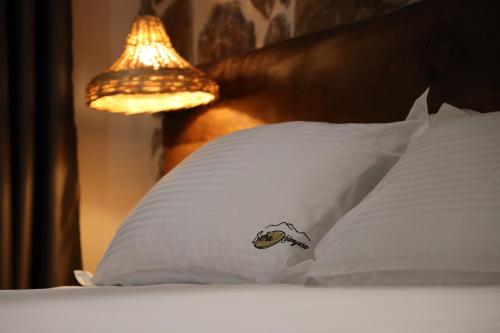 a bed with a pillow with a fish sticker on it at Sofra Kolonjare in Ersekë