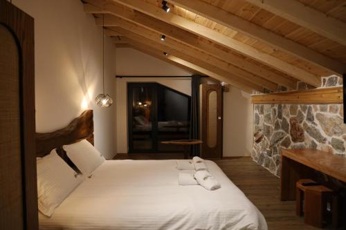 ErsekëにあるSofra Kolonjareのベッドルーム1室(白いベッド1台、タオル付)