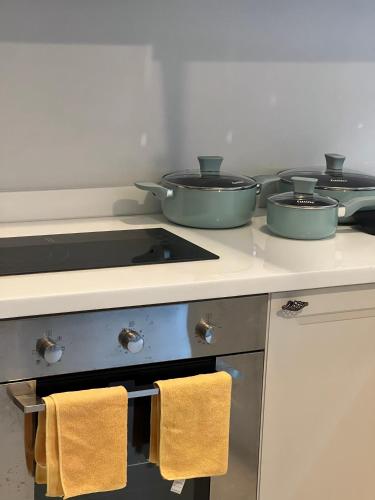 a kitchen with three pots and pans on a stove at Entire 3BR Townhome in Sukhumvit, shared Pool, near BTS&MRT Asok in Bangkok