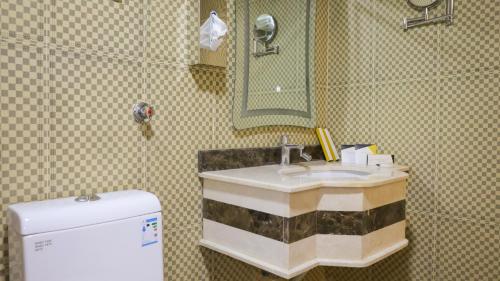 bagno con lavandino, specchio e frigorifero di فندق فاندال a Jazan