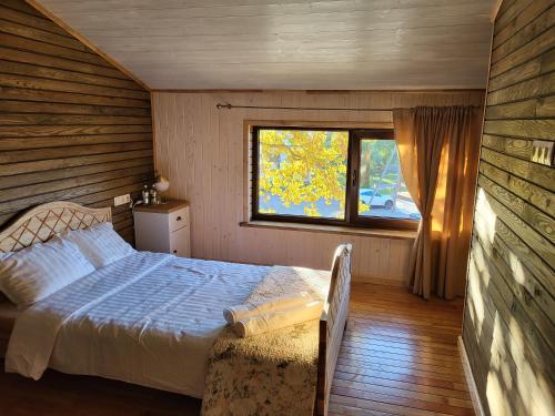 un dormitorio con una cama y una ventana en Pauliankos Pakalnė 1, en Krakiai