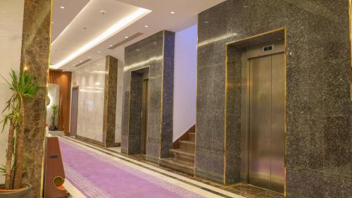 um corredor de um hotel com uma porta e escadas em فندق فاندال em Jazan