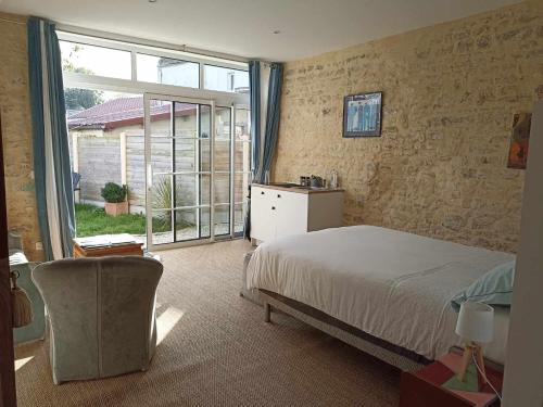 une chambre avec un lit et une grande fenêtre dans l'établissement Studio Vargas avec jardin - Omaha Beach, à Colleville-sur-Mer