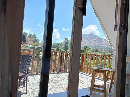 a view from the door of a balcony with a table and chairs at Batur Homestay and Lodge in Bangli