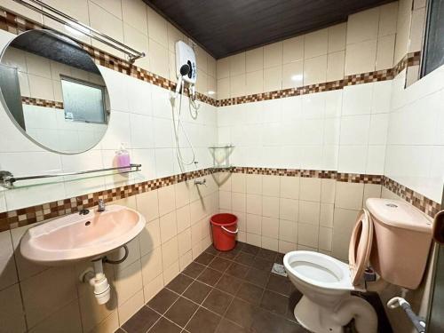a bathroom with a sink and a toilet and a mirror at KK City A2Z Api Api Modern Studio Homestay in Kota Kinabalu