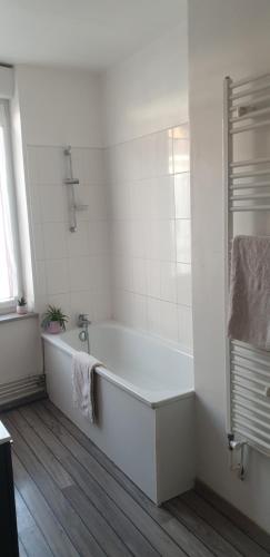 La salle de bains blanche est pourvue d'une baignoire et d'un lavabo. dans l'établissement Olympic games - House near the stadium, à Lille