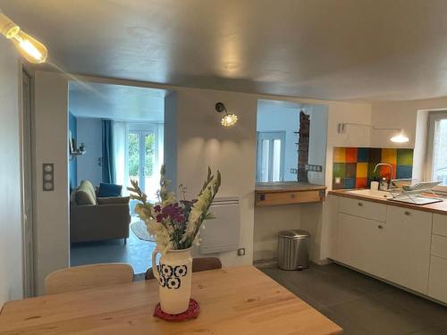 une cuisine avec une table avec un vase de fleurs dessus dans l'établissement Gîte avec terrasse, à Saint-Saturnin
