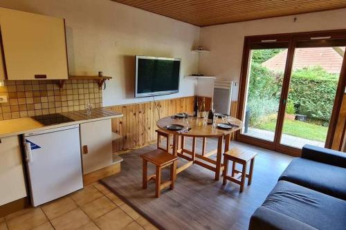 - une cuisine avec une table et un canapé dans une chambre dans l'établissement Gîte Le Bressaud, à La Bresse