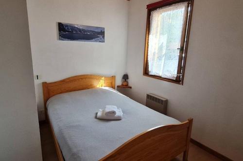 - une chambre avec un lit et une serviette blanche dans l'établissement Gîte Le Bressaud, à La Bresse