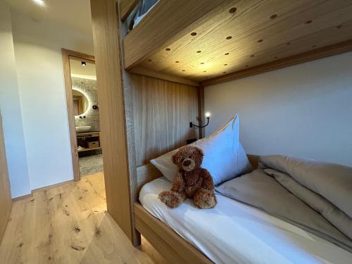 a teddy bear sitting on top of a bed at Residence Sägemühle in Prato allo Stelvio