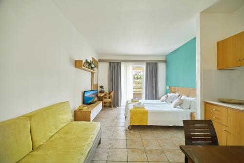 a hotel room with a bed and a couch at Pegasus Hotel in Stalos