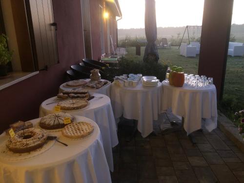 een groep van drie tafels met witte tafelkleden bij Agriturismo Ca' Pisani in Porto Viro