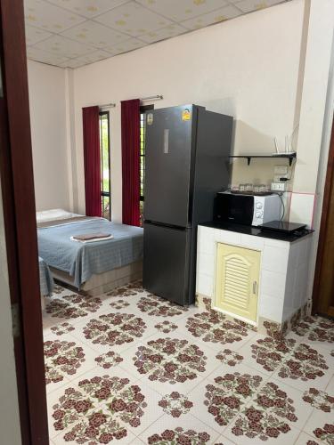 a kitchen with a refrigerator and a bed in a room at Fine Times Resort in Ko Chang