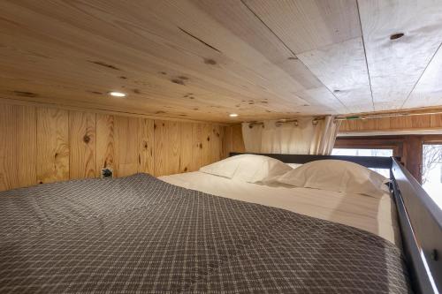 Résidence Les Crêts 1 - Val-d'Isère في فال ديزير: سرير كبير في غرفة ذات سقف خشبي