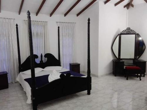 a bedroom with a bed and a mirror and a chair at Madikale Resort in Mirigama