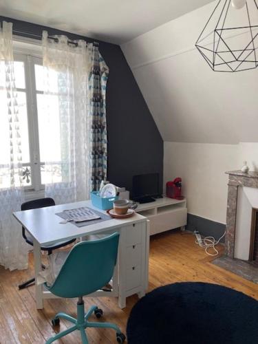 una camera con una scrivania con sedie e una finestra di Chambres cosy dans une maison meulière de charme a Saint-Maur-des-Fossés