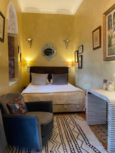 a bedroom with a bed and a chair and a couch at Riad El Arsat & Spa in Marrakech