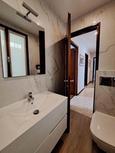 La salle de bains est pourvue d'un lavabo, de toilettes et d'un miroir. dans l'établissement Villa del Pescatore, à San Siro