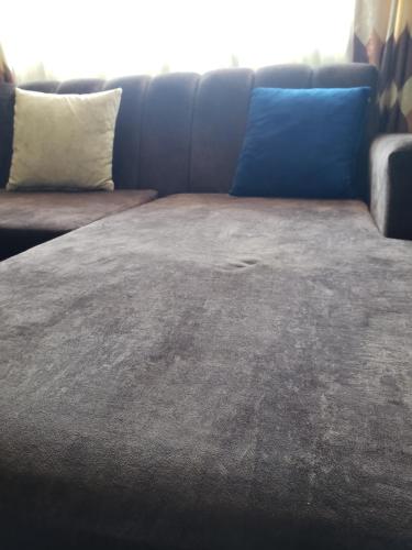 a couch with two pillows on top of it at Yugeen Airbnb in Mombasa
