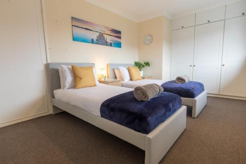 1 dormitorio con 2 camas con cojines azules en ZSKstays! Comfortable home, nice area, free parking and large garden! en Hull